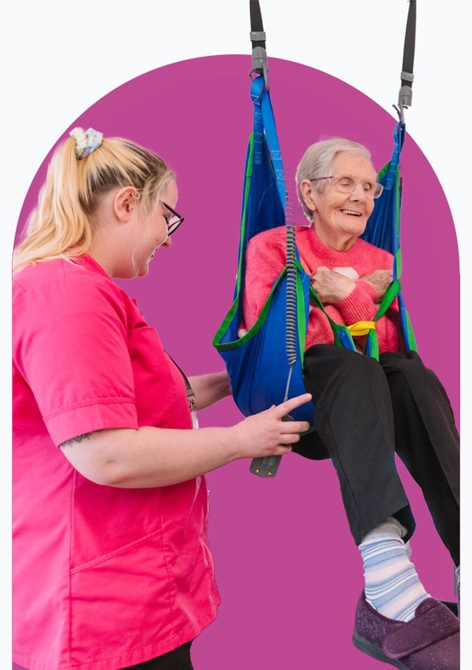 Female Mobility Care client in hoist operated by female Home Carer