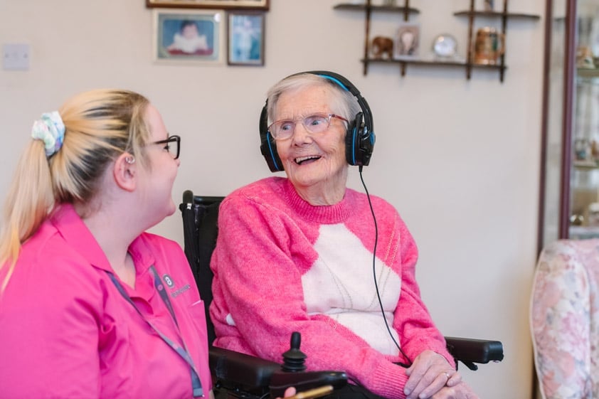 Female Home Carer & female client listening to music