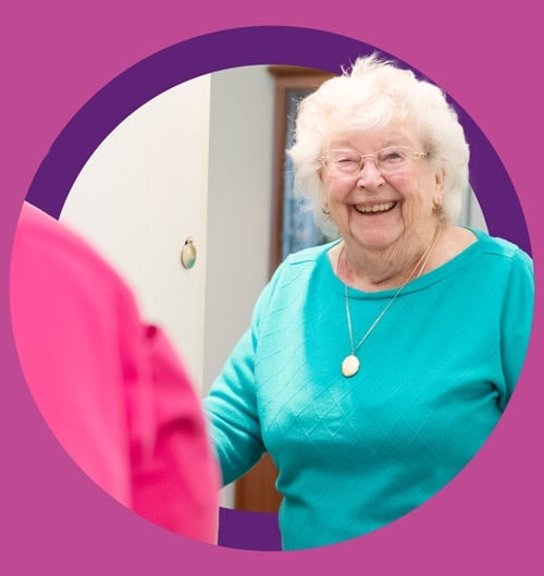 Female client smiling opening the door to Home Carer