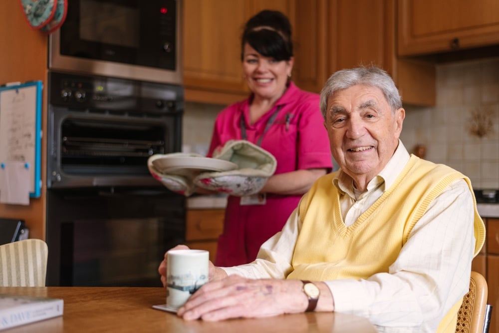 Female Home Carer preparing meal for male client