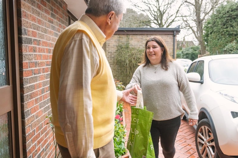 Elderly male receiving shopping assistance from female Carer