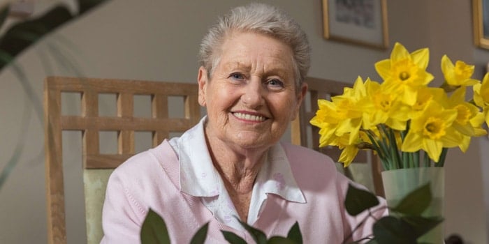 Female client smiling with yellow flowers