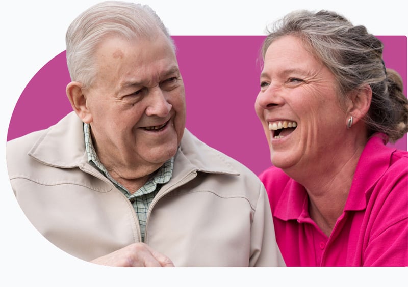 Male client and female carer laughing whilst receiving palliative care