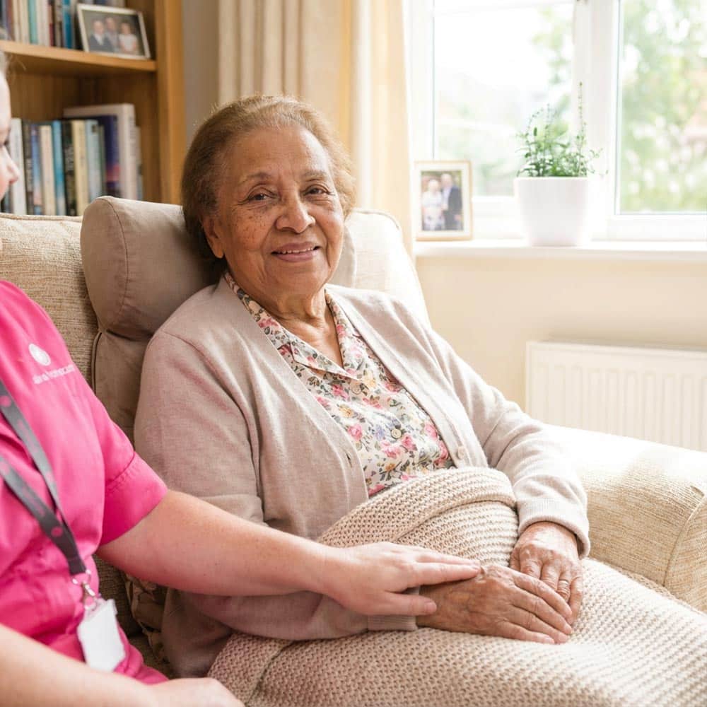 Female client who is receiving care after a hospital visit, smiling at the camera